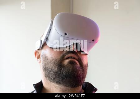 Amazed bearded man in VR glasses exploring virtual reality. Male in virtual reality headset. Modern technology for work, education and entertainment Stock Photo