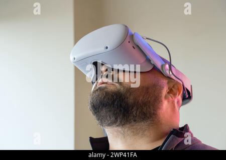 Bearded man in virtual reality headset looking up. Male in VR glasses. Modern technology for work, education and entertainment concept Stock Photo