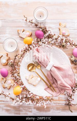 Easter table setting with colorful eggs and homemade bunny cookies Stock Photo