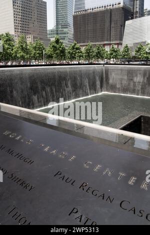 The reflecting pool at the 9/11 Memorial in New York City, with the surrounding buildings reflected in the water. Stock Photo