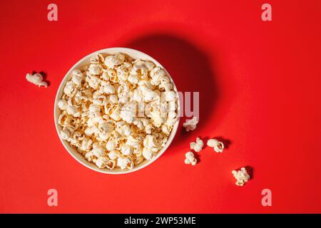 Popcorn in a bow isolated on red background, movie night Stock Photo