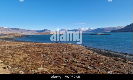 Beautiful frozen lake and snowy hilltops in iceland, magical pure icelandic wilderness. Massive water spot with frosty hills and meadows creating natural environment, nordic scenery. Stock Photo