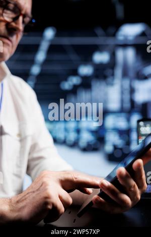 Computer scientist coding in high tech data center using javascript language, close up. Skillful worker updating software on server rigs on tablet terminal, ensuring optimal performance and security Stock Photo