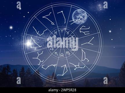 Zodiac wheel with symbols and constellation stick figure patterns against mountain landscape Stock Photo