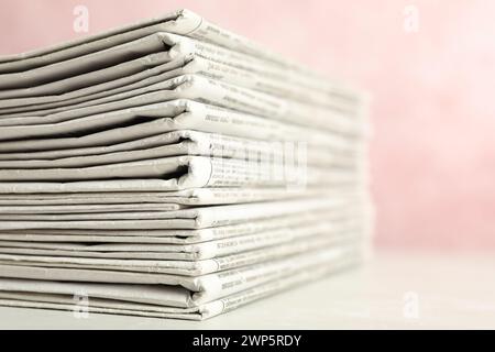 Stack of newspapers on pink background, closeup. Journalist's work Stock Photo