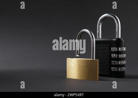 Different padlocks on black background, closeup. Space for text Stock Photo