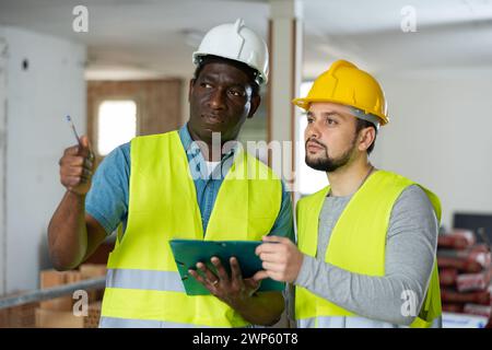Two engineers discussing work in apartment Stock Photo