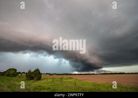A severe thunderstorm dumps rain and hail on a flat landscape in the plains. Stock Photo