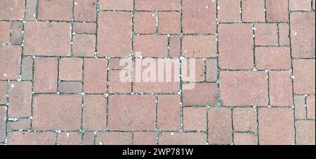Cobbled street of the old city, lined with square and rectangular stone tiles. Soft beige, brown and gray colors and tones. The texture of the stone Stock Photo