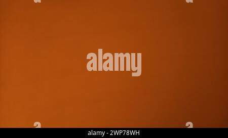 Dark saturated orange paper with a transition from light orange to light brown. Light tone on the left, dark on the right. Texture, background, postca Stock Photo