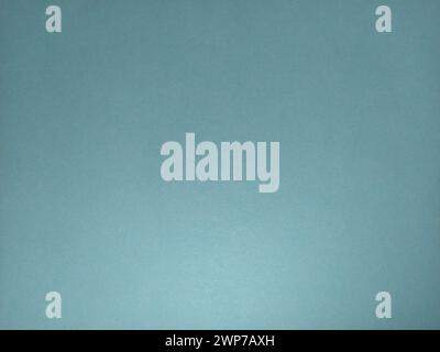 A sheet of paper or thin cardboard in blue. Lighting on the one hand. Light and shadow. Cellulose texture. Calm, soft, cold tone. Background. Stock Photo