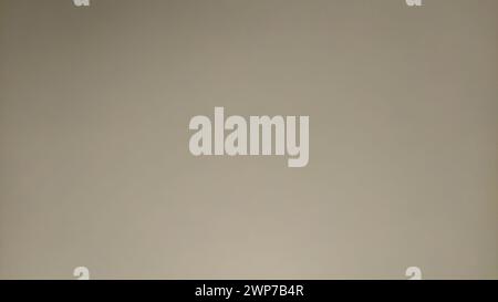 Beige background with lighting in the middle of the sheet. Paper or cardboard texture. Stock Photo