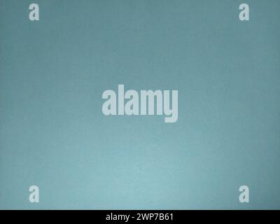 A sheet of paper or thin cardboard in blue. Lighting on the one hand. Light and shadow. Cellulose texture. Calm, soft, cold tone. Background. Stock Photo