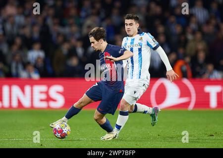 Vitinha of Paris Saint-Germain competes for the ball with Ander Barrenetxea of Real Sociedad during the UEFA Champions League, Round of 16, 2nd leg football match between Real Sociedad and Paris Saint-Germain on March 5, 2024 at Reale Arena in San Sebastian, Spain Stock Photo