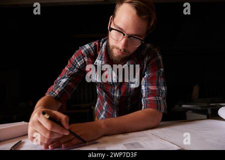 Man, architect and table or paper, thinking and working on planning for construction. Architecture, building or engineering for infrastructure, design Stock Photo