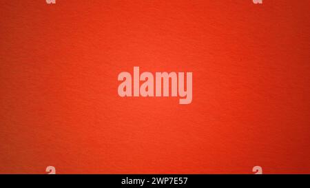 A sheet of bright red paper with light vignetting around the edges. Passionate red color. Saturated bright paint. Paper texture. Background for greeti Stock Photo