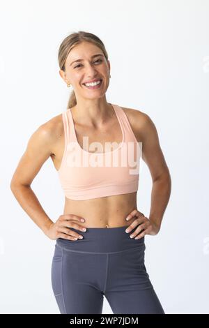 A young Caucasian woman poses confidently in activewear Stock Photo