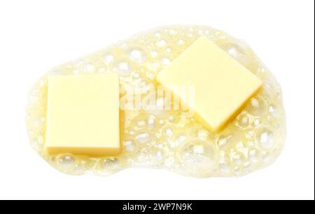 Two pieces of butter melting isolated on white background Stock Photo