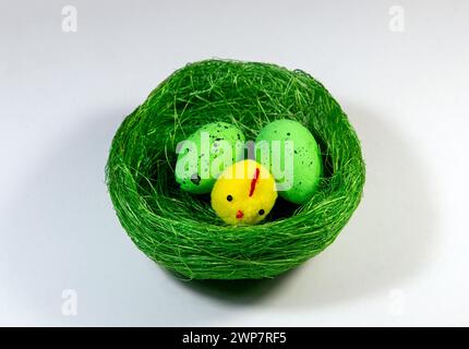 A decorative artificial nest with eggs and chicks on a white background. Easter arrangement symbol Stock Photo