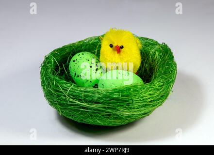 A decorative artificial nest with eggs and chicks on a white background. Easter arrangement symbol Stock Photo