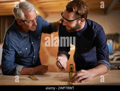 Architecture, teamwork and senior mentoring man in workplace of workshop, pencil and drawing. Male people, professional and working with measuring Stock Photo