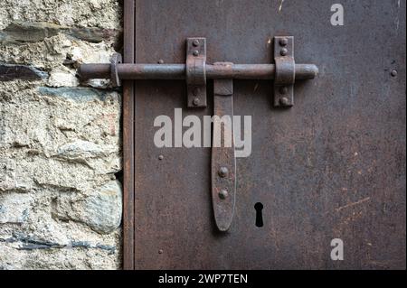 Detail of the old bolt or latch made in the forging of a metal door Stock Photo