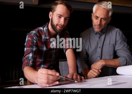 Architects, discussion and men with blueprint in office for building, construction or repairs. Engineering, design and industrial apprentice planning Stock Photo