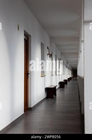 A long, straight corridor with white walls Stock Photo