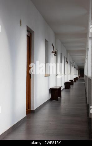 A long, straight corridor with white walls Stock Photo