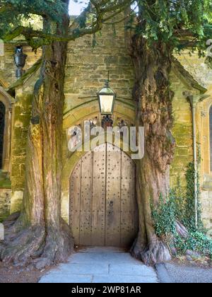 Hidden away in the grounds of the historic St EdwardÕs Church Stow-on-the-Wold in the Cotswolds can be seen this magical medieval church door flanked Stock Photo