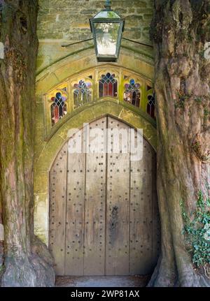 Hidden away in the grounds of the historic St EdwardÕs Church Stow-on-the-Wold in the Cotswolds can be seen this magical medieval church door flanked Stock Photo