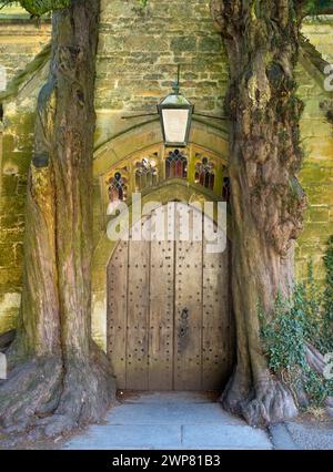 Hidden away in the grounds of the historic St EdwardÕs Church Stow-on-the-Wold in the Cotswolds can be seen this magical medieval church door flanked Stock Photo