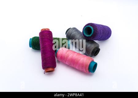 Pile of colorful sewing threads on isolated white background.Colored yarns used by factories in the clothing industry. Stock Photo