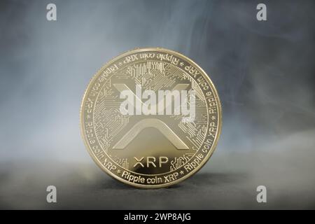 A close-up of XRP Ripple Cryptocurrency Golden coin with smoke effect Stock Photo