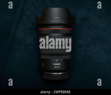 A Canon RF 24-70 F2.8 IS USM mirrorless full frame lens on a dark background Stock Photo