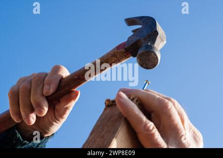 Two hands nailing On a construction site in southern Germany Stock Photo