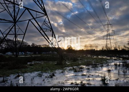I love electricity pylons; I find their abstract, gaunt shapes endlessly fascinating. Here we see giant pylons in a field by the Thames at Kennington, Stock Photo