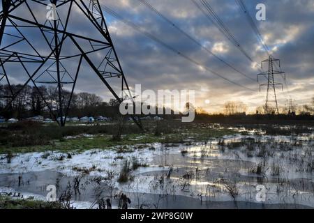 I love electricity pylons; I find their abstract, gaunt shapes endlessly fascinating. Here we see giant pylons in a field by the Thames at Kennington, Stock Photo