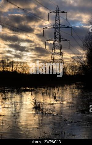 I love electricity pylons; I find their abstract, gaunt shapes endlessly fascinating. Here we see giant pylons in a field by the Thames at Kennington, Stock Photo