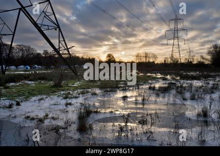 I love electricity pylons; I find their abstract, gaunt shapes endlessly fascinating. Here we see giant pylons in a field by the Thames at Kennington, Stock Photo