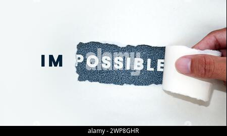 Torn paper separates the words Impossible from possible Stock Photo