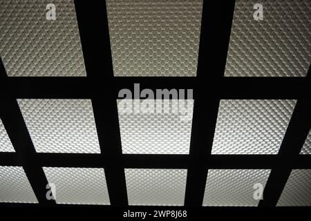 Electric LED light in the elevator. The ceiling of the elevator car. Checkered light source, horizontal and vertical metal lines and corrugated glass Stock Photo