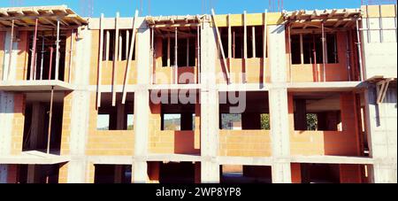 Red ceramic bricks at the construction site. Keramoblock. Hollow brick. Construction of a red brick building. Material for the construction of walls Stock Photo