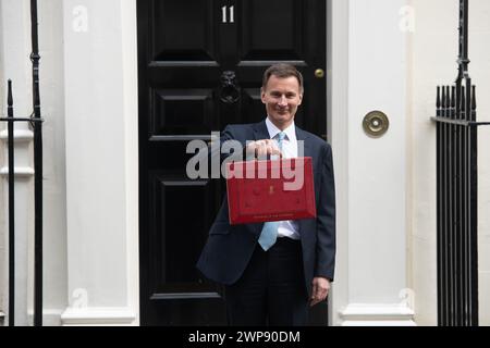 London, UK. 06 Mar 2024. Jeremy Hunt - Chancellor of The Exchequer holds up the Red briefcase containing the budget speech as he departs 11 Downing Street for Parliament where he will make a statement on the Spring Budget 2024. Credit: Justin Ng/Alamy Live News. Stock Photo