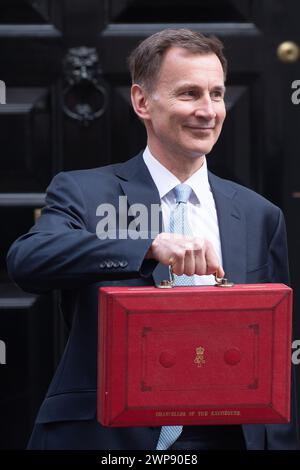 London, UK. 06 Mar 2024. Jeremy Hunt - Chancellor of The Exchequer holds up the Red briefcase containing the budget speech as he departs 11 Downing Street for Parliament where he will make a statement on the Spring Budget 2024. Credit: Justin Ng/Alamy Live News. Stock Photo