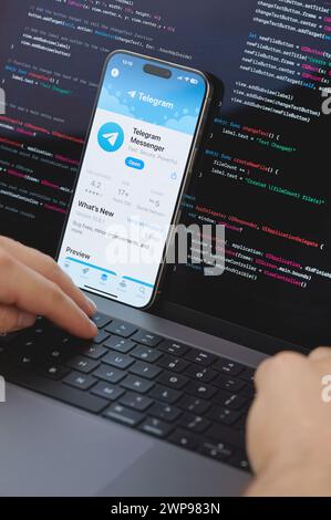 New York, USA - February 23, 2024: Code for new Telegram app in laptop screen with hands on keyboard Stock Photo