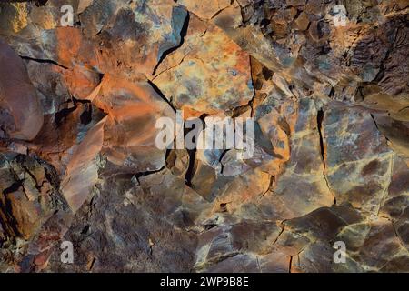 Colorful abstract mineral texture background with vibrant hues on rocky surface. Suitable for geological themes or artistic designs. Location: The Cav Stock Photo