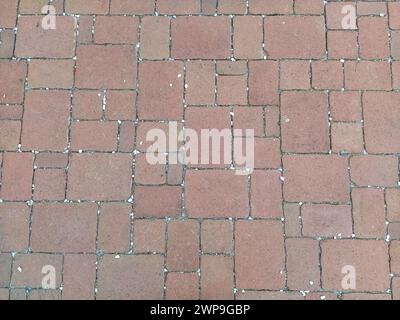 Cobbled street of the old city, lined with square and rectangular stone tiles. Soft beige, brown and gray colors and tones. The texture of the stone Stock Photo