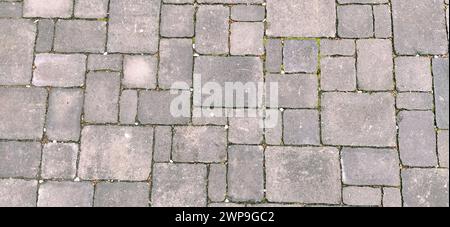 Cobbled street of the old city, lined with square and rectangular stone tiles. Soft beige, brown and gray colors and tones. The texture of the stone Stock Photo