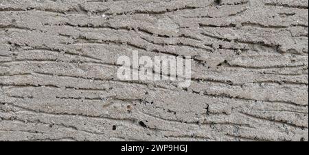 Light and shadow. Wall of the house with a self-made plastered facade. The cement mortar is applied to the wall, smeared with a spatula. Decorative Stock Photo